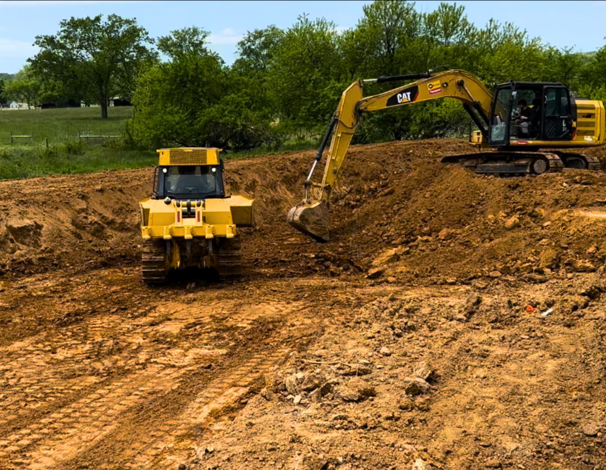 CAT excavator and dozer digging pond basin