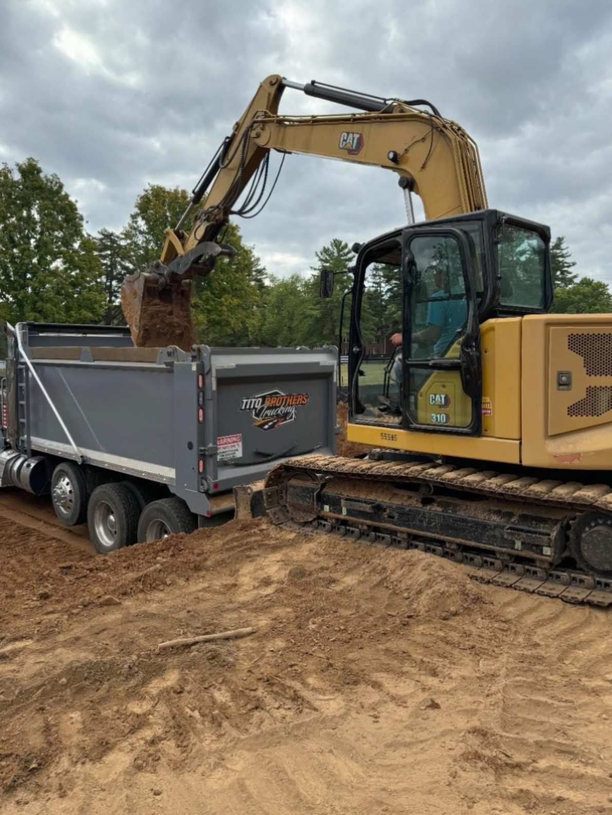 CAT excavator loading Tito Brothers dump truck